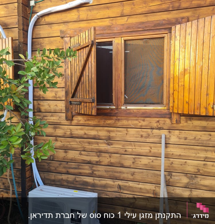 יחידת מזגן חיצונית מותקנת על קיר עץ